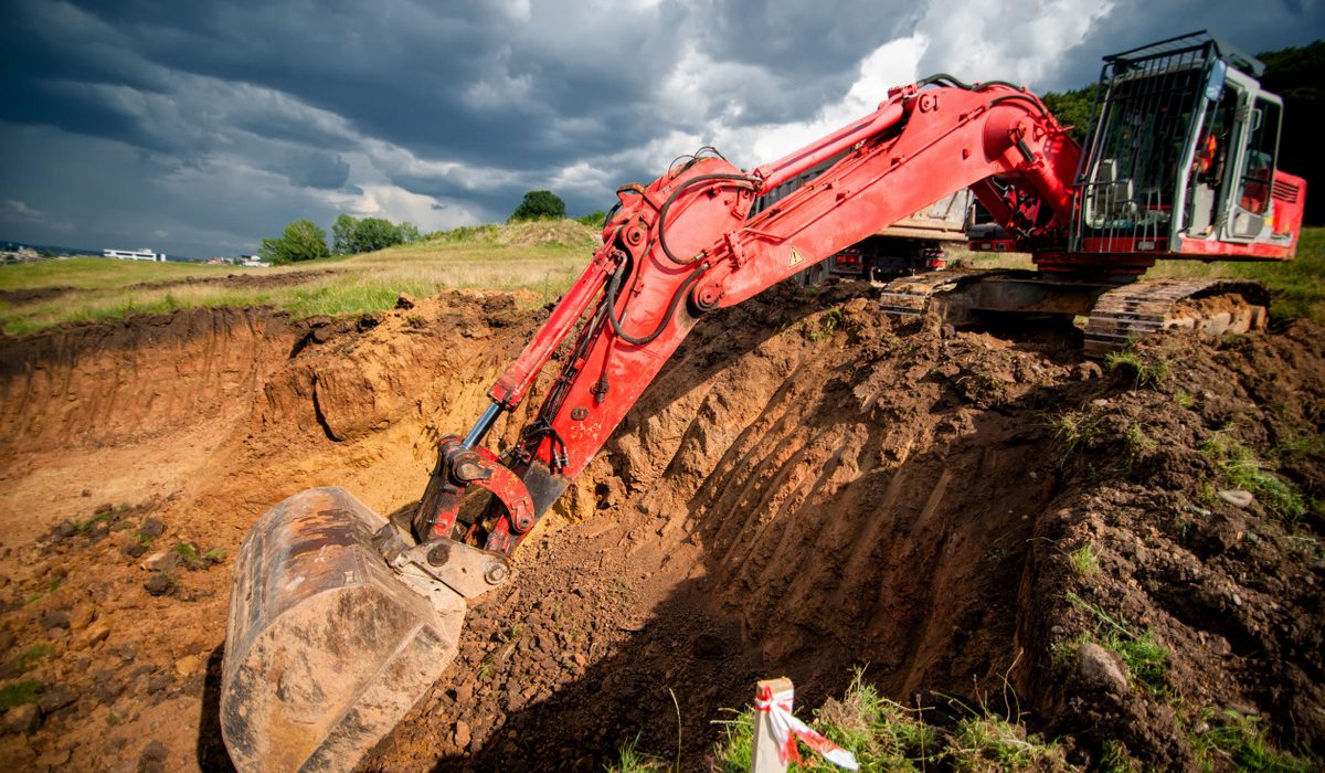 industrial excavator loading soil from highway construction site